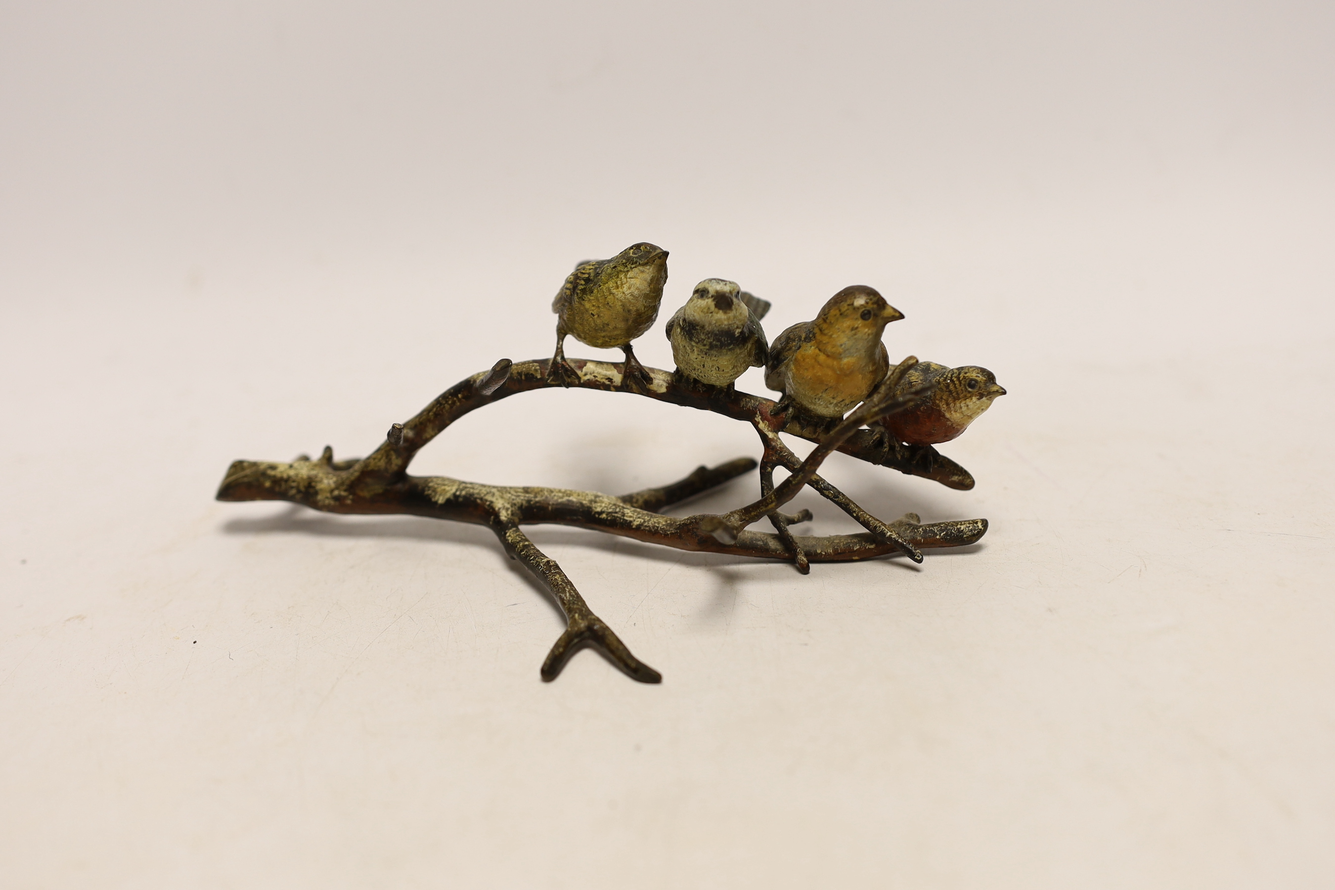 An Austrian cold painted bronze group of four birds on a branch, stamped Geschutz, 19cm long
